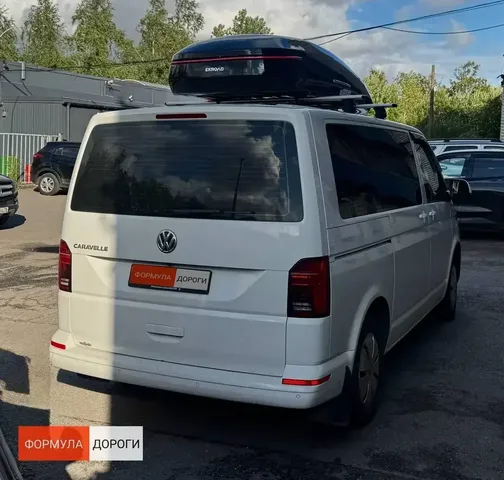 Бокс на крышу ENROAD Nomadix Pro XXL 600-E для Volkswagen Multivan (T6), 4-дв. Van, 2015–, цвет «Чёрный» — задний ракурс автомобиля под углом и нависание автобокса
