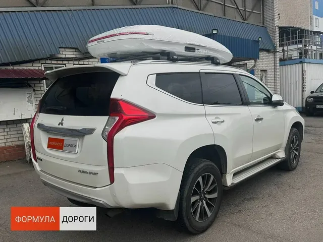 Бокс на крышу ENROAD Nomadix Pro XL Slim 400-E для Mitsubishi Pajero Sport, цвет «Белый» — общий ракурс автомобиля с установленным автобоксом